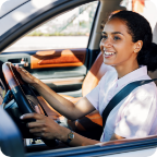 A woman smiles as she drives. 